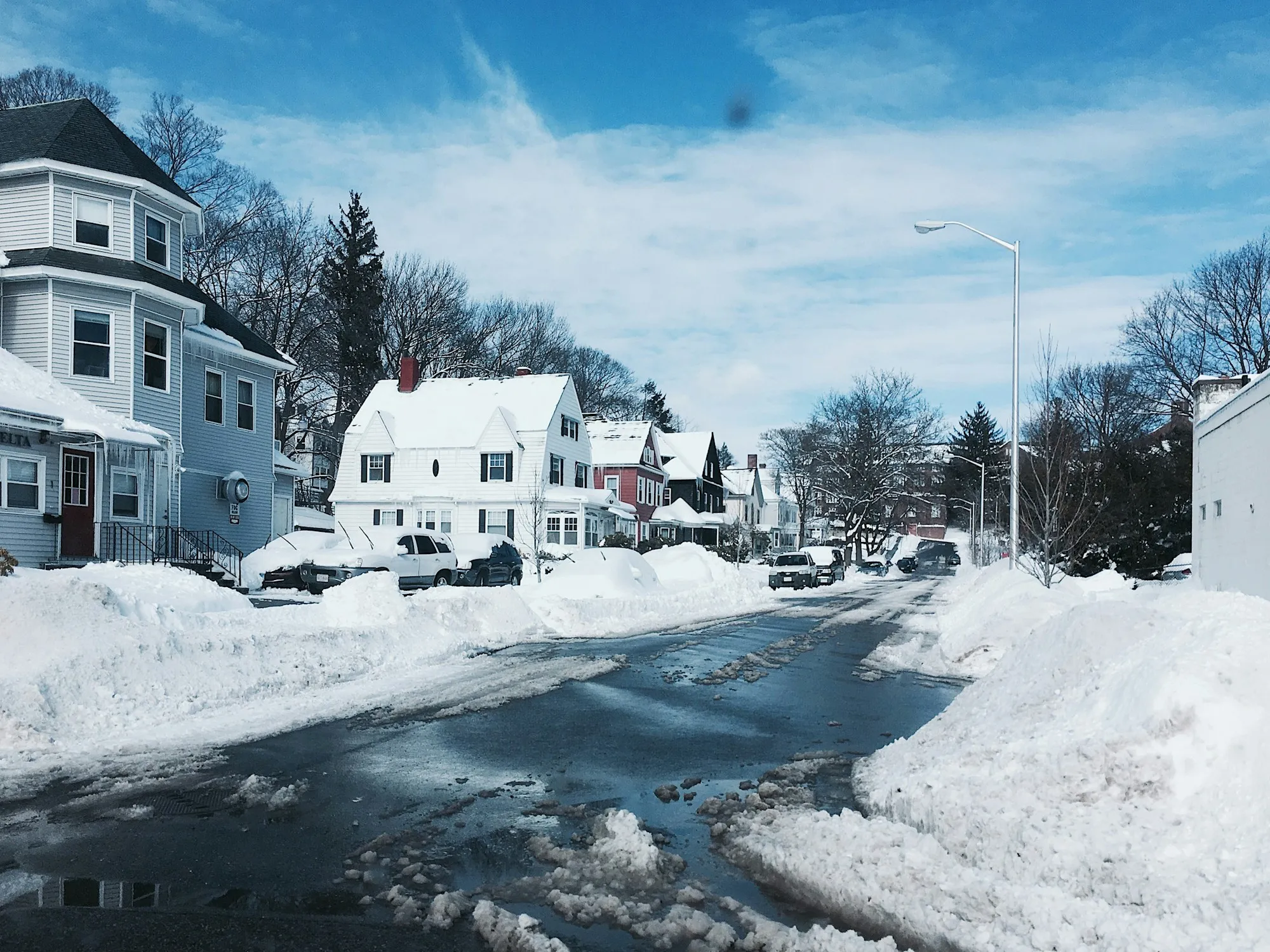 Snow-covered residential street lined with houses