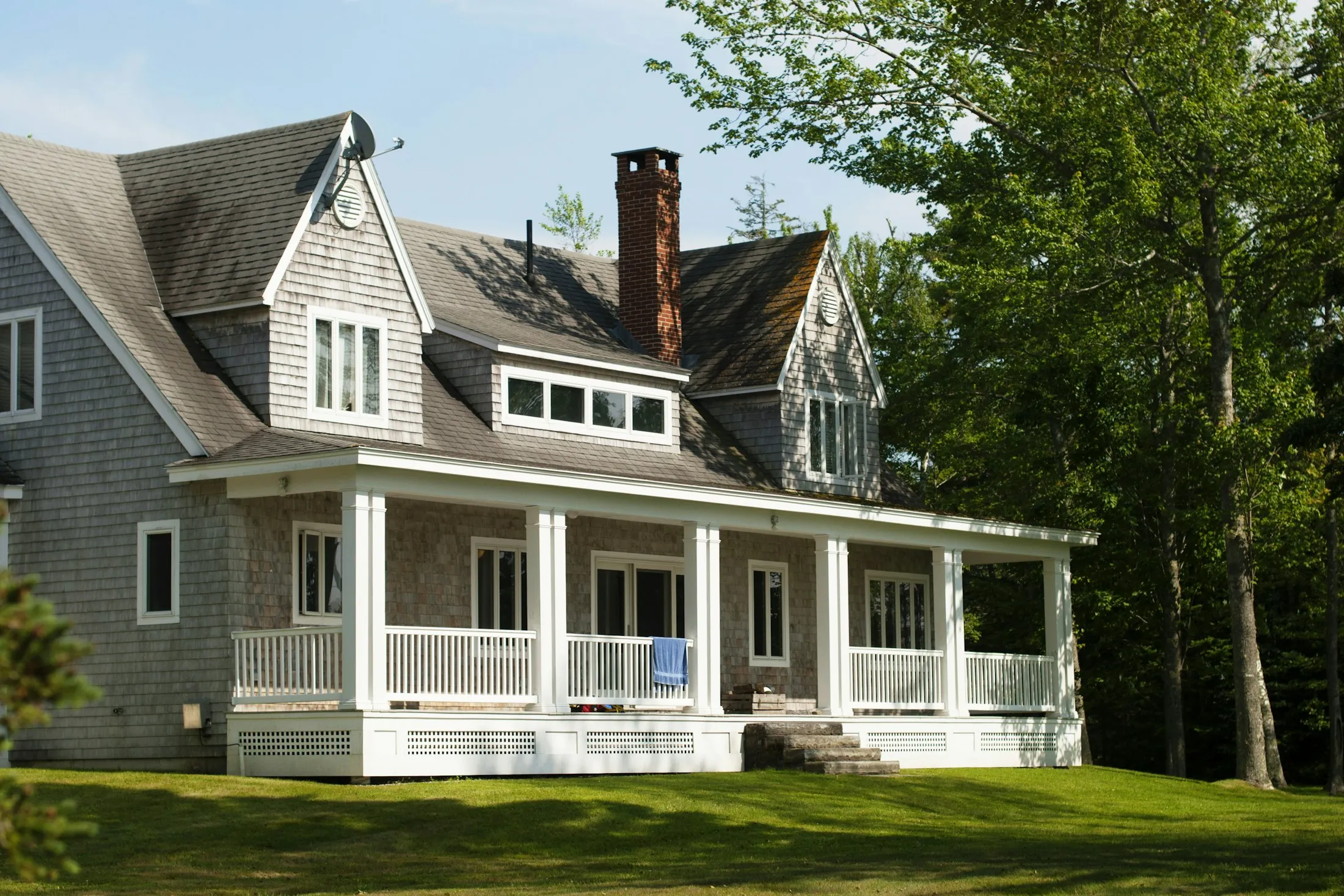 Shingled house with a front porch and lawn